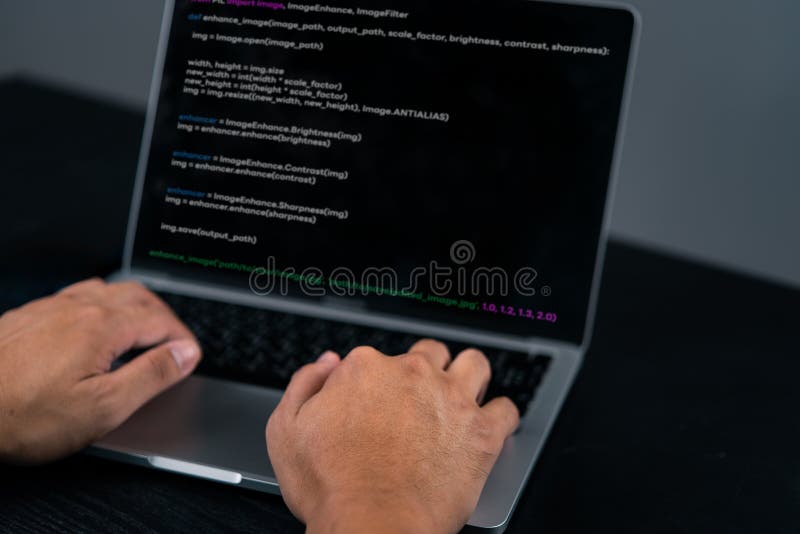 Close-up of a programmer's hands coding on a laptop. Highlights the software development process and coding environment. stock image
