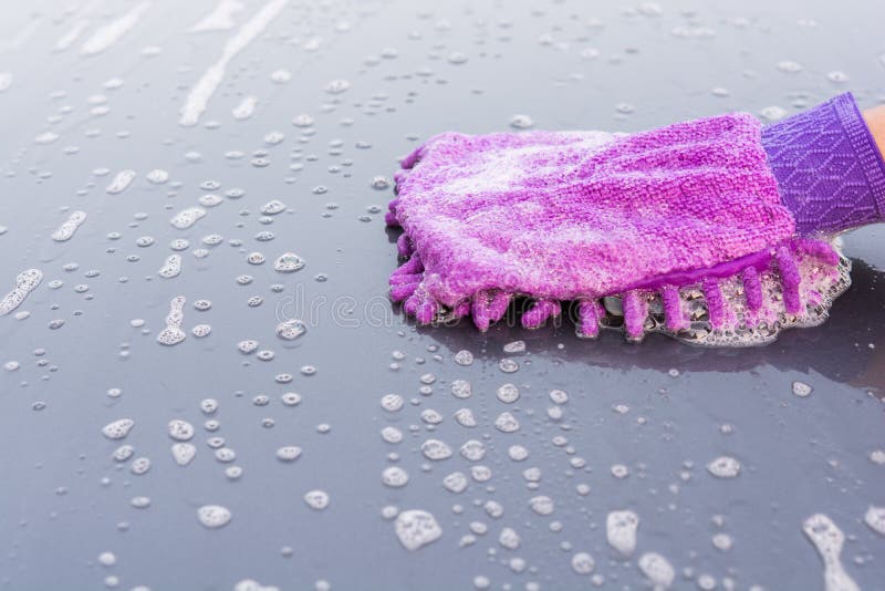 Closeup cleaning his car using gloves car wash gray color. Closeup cleaning his car using gloves car wash gray color