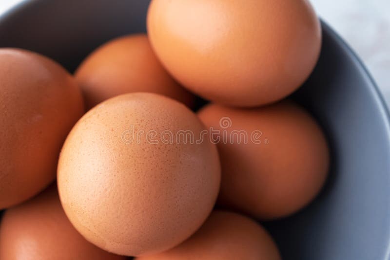 Close-up raw brown organic eggs, top view. Macro chicken eggs in gray bowl stock photo Close-up raw brown organic eggs, top view. Macro chicken eggs in gray bowl stock photo
