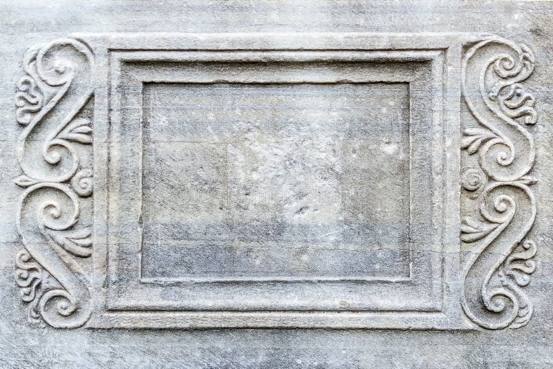 Close-up of rectangular frame with engraved ornament on ancient stone sarcophagus in a public park. stock photo Close-up of rectangular frame with engraved ornament on ancient stone sarcophagus in a public park. stock photo