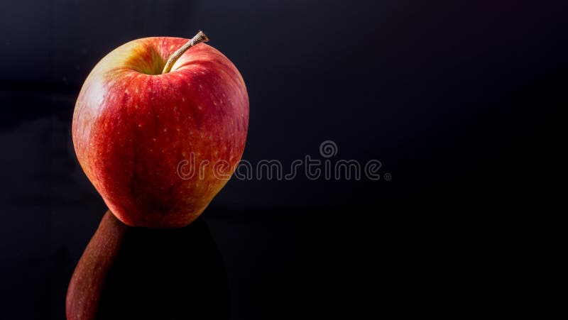 Close up of a red apple on a black mirroring background - copy-space. Mirroring object stock images, royalty-free photos and pictures