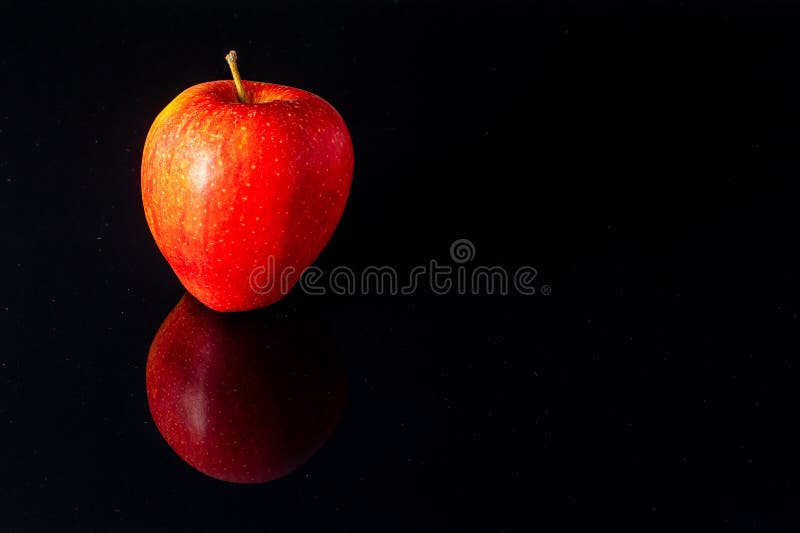Close up of a red apple on a black mirroring background - copy-space. Mirroring object stock images, royalty-free photos and pictures