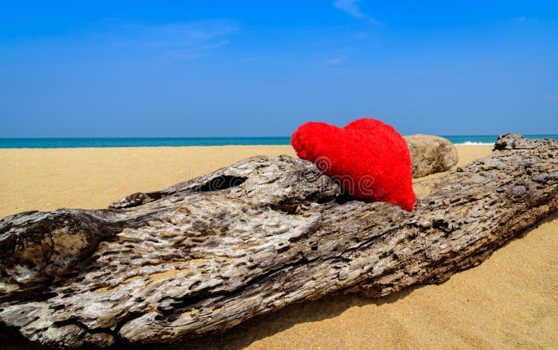 Close up red hearts on ocean beach sand - love concept for holidays