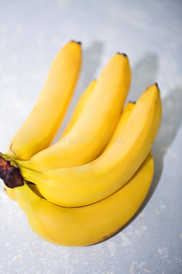 Close-up of ripe yellow bananas on grey background. Fruit, healthy food, market concept royalty free stock photo Close-up of ripe yellow bananas on grey background. Fruit, healthy food, market concept royalty free stock photo