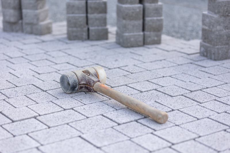 Close up of a rubber mallet on the new concrete pavement, building a new path concept stock photography