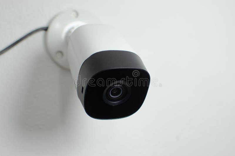Closeup of a Security Camera Mounted on a Wall in a Modern Office, Ready To Be Used Stock Photo
