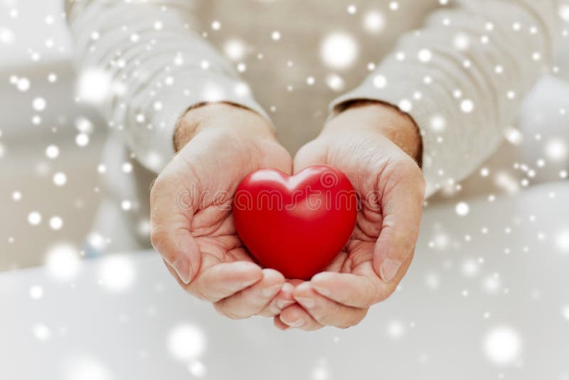 Close up of senior man with red heart in hands