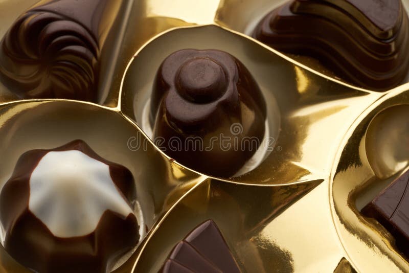 Closeup of Several Assorted Chocolates in a Yellow Packing Box Stock