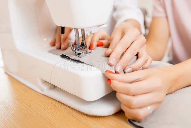 Closeup of Seamstress Threading Needle in Sewing Machine Stock Photo