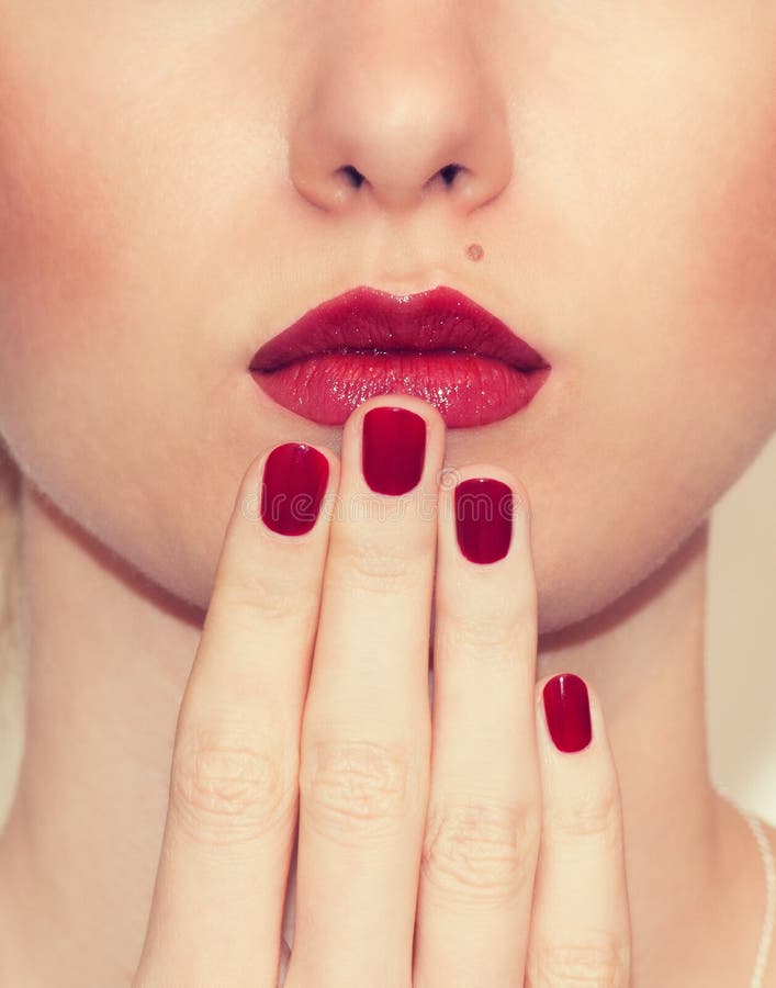 Close up 'sexy' vermelho dos bordos e dos pregos Boca fechada Tratamento de mãos e composição imagem de stock Close up 'sexy' vermelho dos bordos e dos pregos Boca fechada Tratamento de mãos e composição imagem de stock