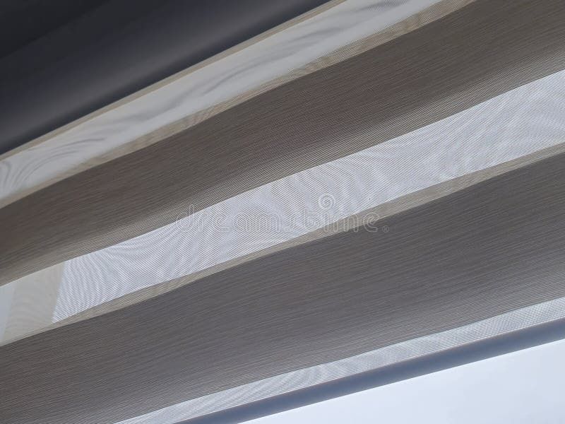 A close-up of sheer fabric curtains letting light in. The texture shows soft, natural colors blending harmoniously. Perf stock image