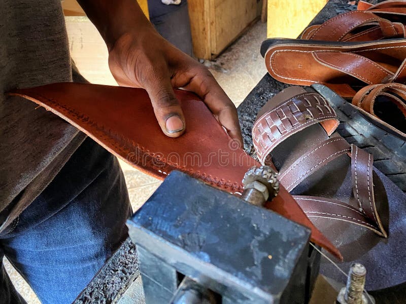 Close Up of Shoemaker Feeding Leather through Embossing Machine Stock