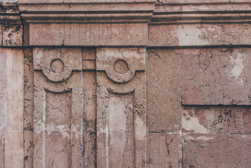 Close-up shot of cracked wall with ancient decor elements royalty free stock photography