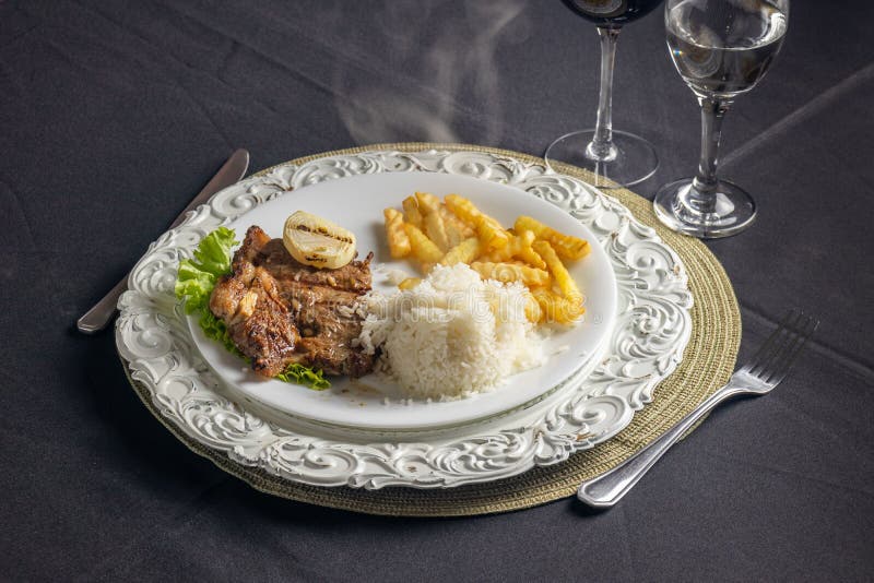 Close-up Shot of a Dish with Rice French Fries and Steak Served on the