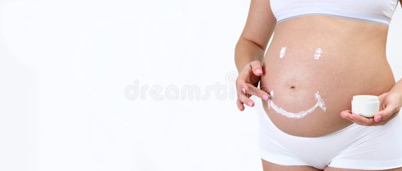 Close-up shot of pregnant woman belly applying cream