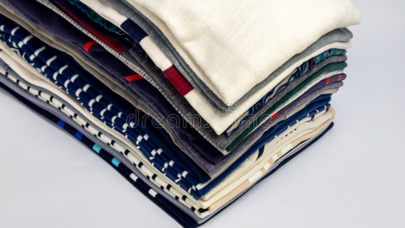 Stack of folded colorful clothing items against a plain white background royalty free stock images