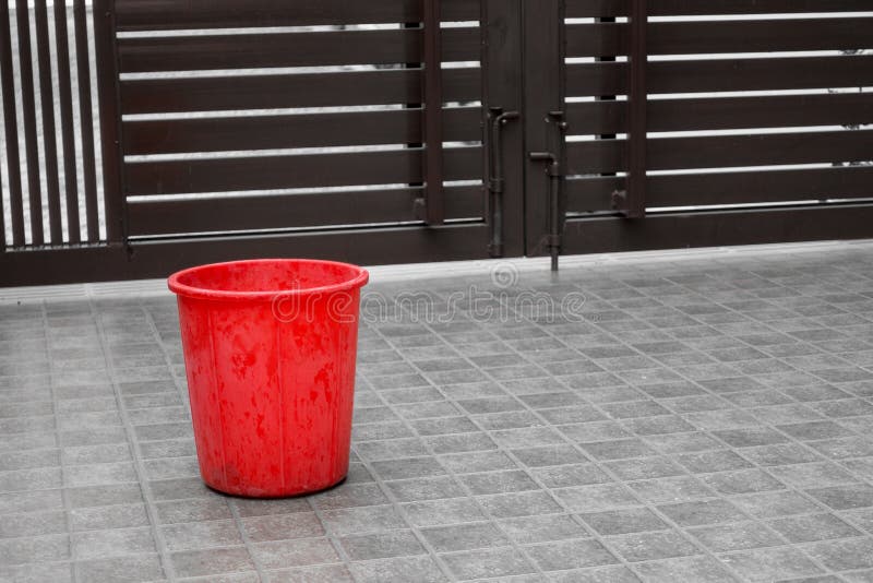 A Close Up Shot of Small Red Bucket on the Tile Floor Stock Photo