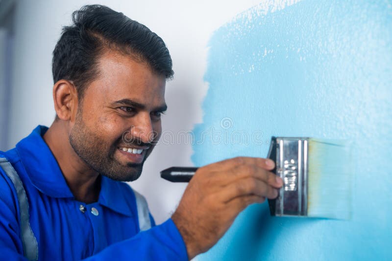 Close Up Shot of Smiling Painter Painting on Wall with Paint Brush on Close Up Shot of Smiling Painter Painting on Wall with Paint Brush on