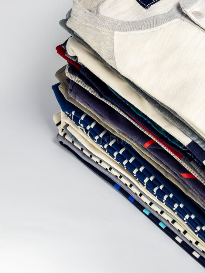 Stack of neatly folded colorful clothes on a white background stock images