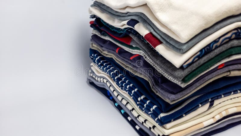 Stack of neatly folded colorful shirts on a clean white background royalty free stock image