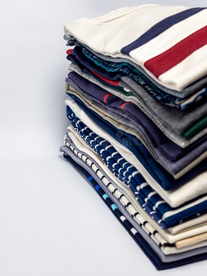 Stacked folded colorful t-shirts ready to wear on a white background royalty free stock images