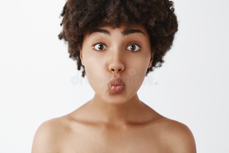 Close-up shot of tender and gentle silly naked woman with afro hairstyle folding lips and awaiting for passionate kiss stock photo Close-up shot of tender and gentle silly naked woman with afro hairstyle folding lips and awaiting for passionate kiss stock photo