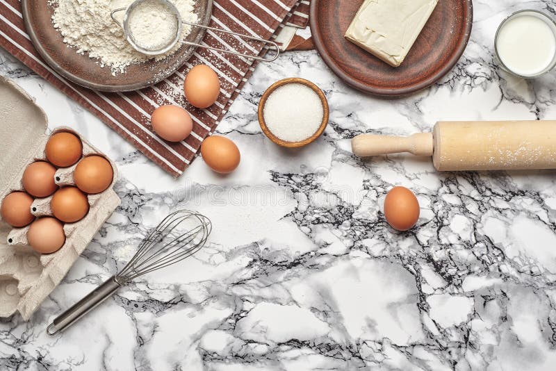 Close-up shot. Top view of a baking ingredients and kitchenware on the marble table background.