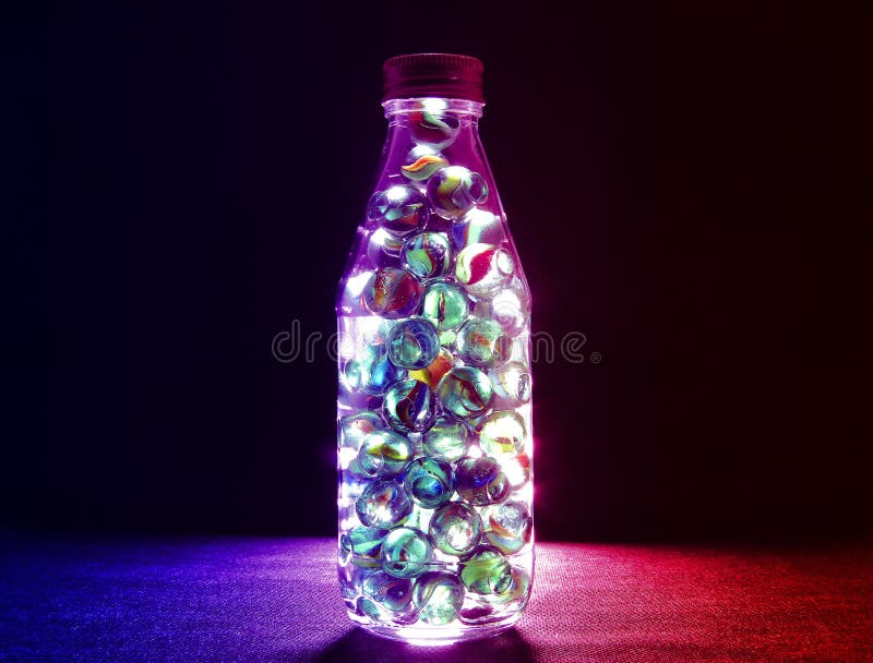 Closeup Shot of Various Colored Glass Marbles Inside a Bottle with