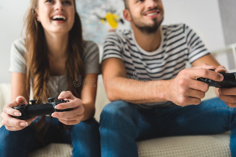 close-up shot of young couple playing games with gamepads