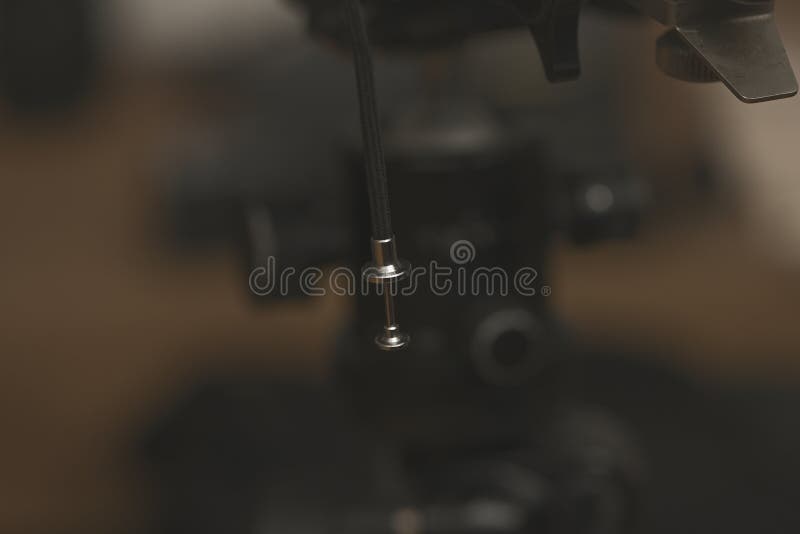 Close up of a shutter release cable tip with braided cord in soft warm studio lighting royalty free stock photography