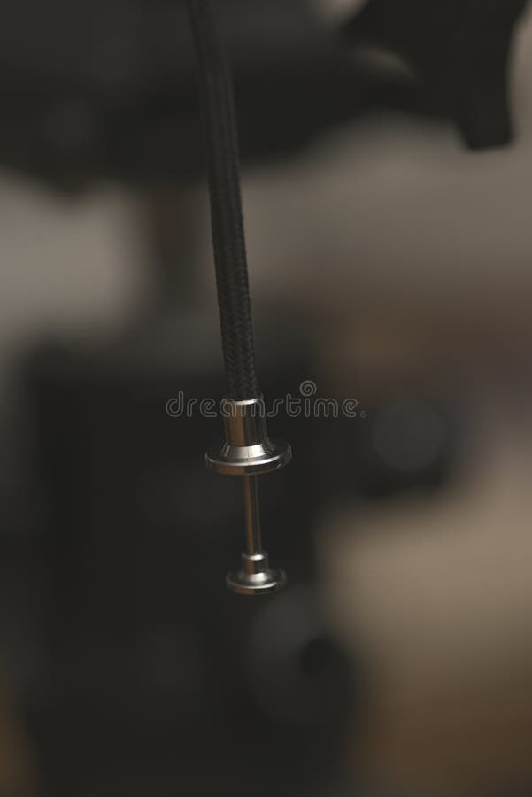 Close up of a shutter release cable tip with braided cord in soft warm studio lighting royalty free stock photography