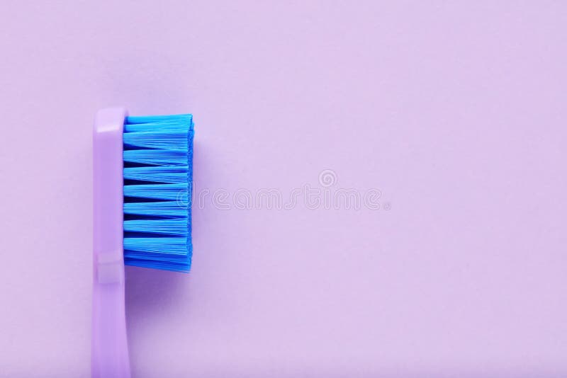 Close up side view of a purple toothbrush on purple background royalty free stock image