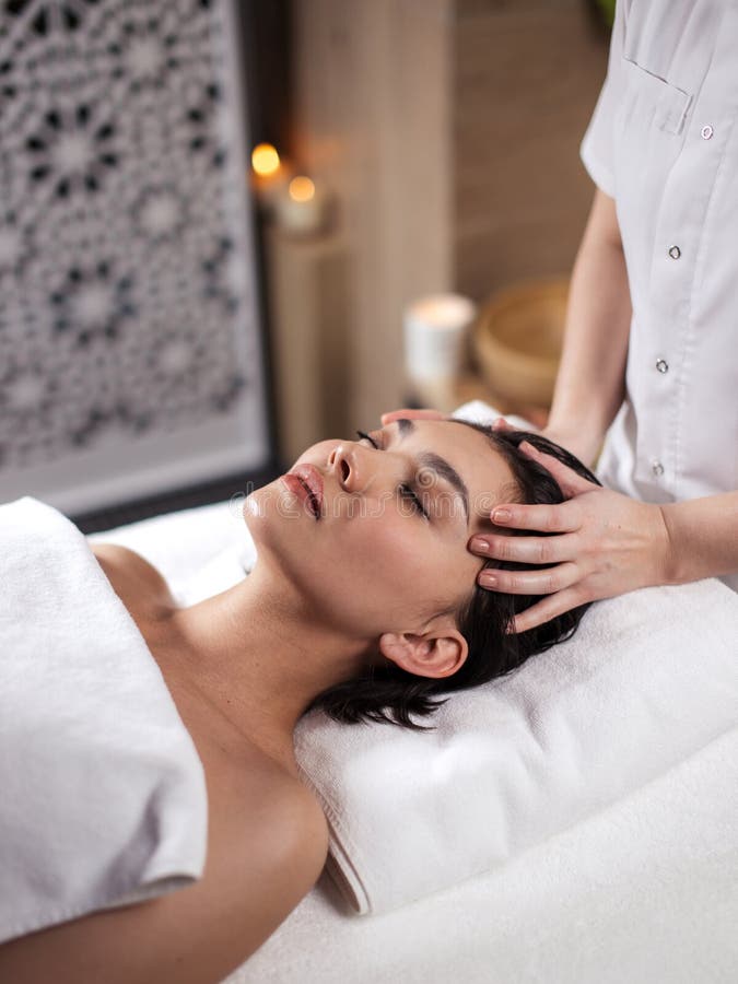 Close up side view shot of woman`s hands massaging aching head