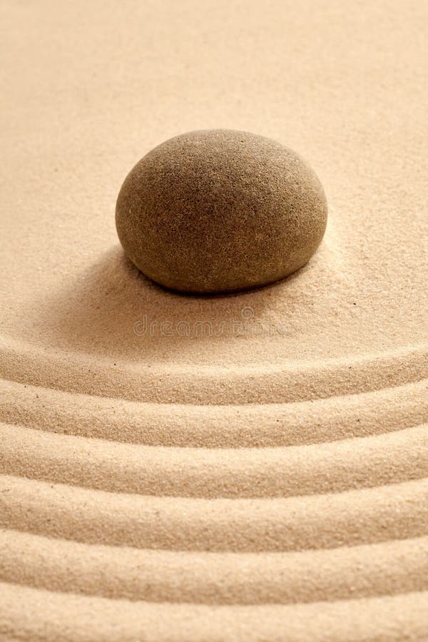 Close up of single stone in zen garden with sand