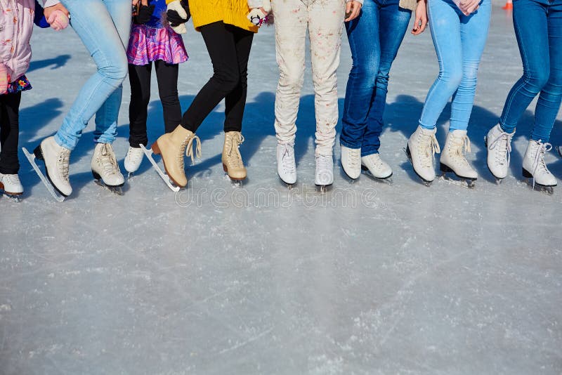 Close-up of the skates from the skaters on the ice surface. Skate on the ice in the company of friends. Skate rental. place for text