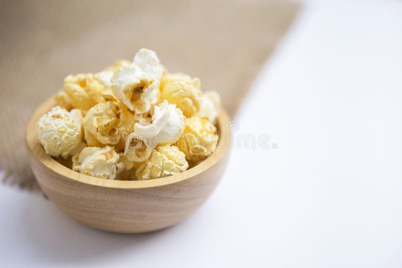 Close-up slated popcorn in ronde houten kom op witte achtergrond royalty-vrije stock fotografie Close-up slated popcorn in ronde houten kom op witte achtergrond royalty-vrije stock fotografie