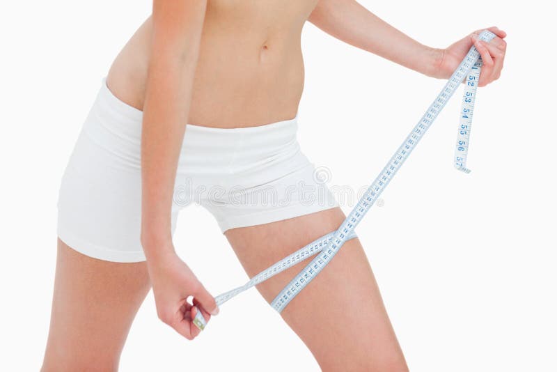 Close Up of Slim Woman Measuring Her Waist`s Size with Tape