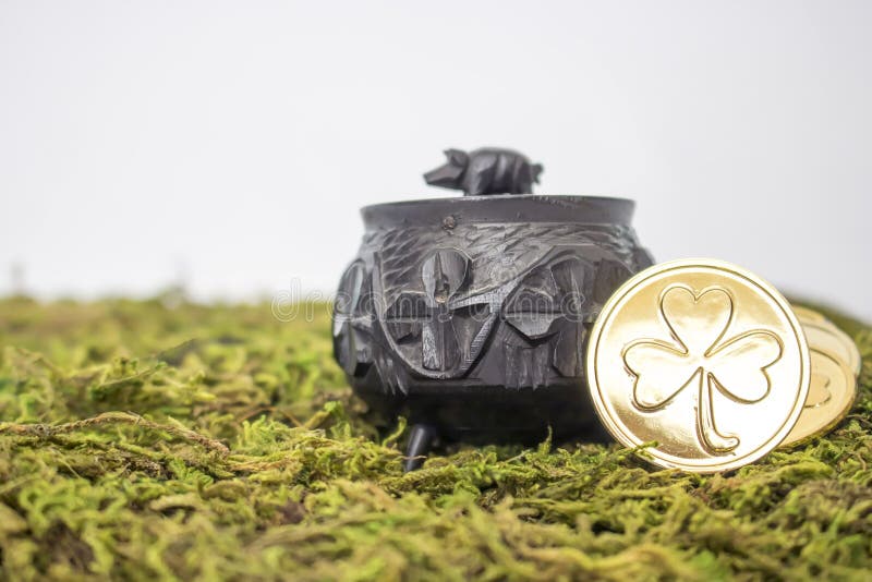 Close Up Small Antique Oak Pot with Shamrocks and Gold Coins on stock photo Close Up Small Antique Oak Pot with Shamrocks and Gold Coins on stock photo