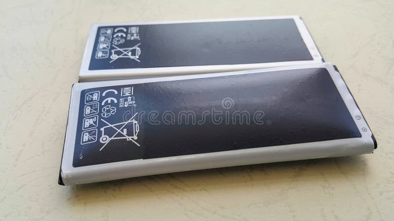 Close-up of the smartphone`s swollen lithium-ion battery. A damaged battery is ready to burn or explode. Near the battery without stock photo