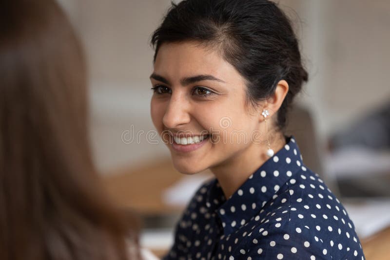 Close up of smiling indian girl talking listening to friend