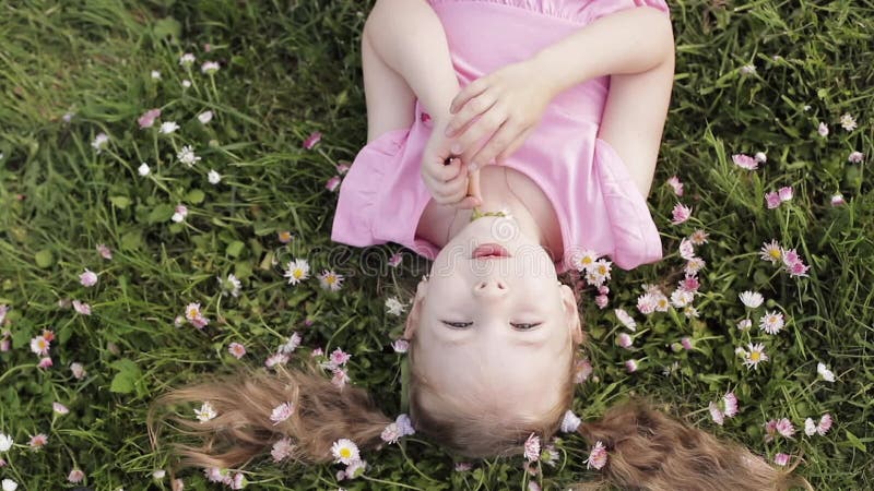 Close-up Smiling Little Cute Baby Girl Lying on Green Grass Holding Flowers Looking at Camera Stock Footage - Video of children, lying: 150804696