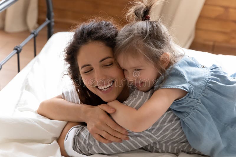 Close Up Smiling Mother And Little Daughter Cuddling In Bed Stock Image 