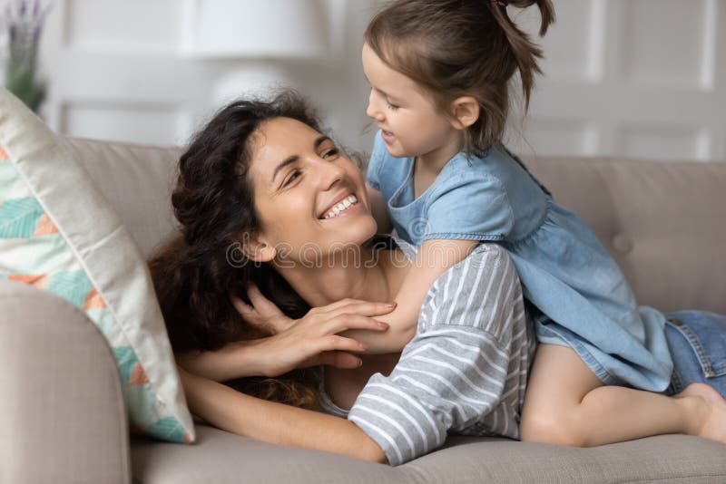 Close Up Smiling Mother And Little Daughter Cuddling On Couch Stock 