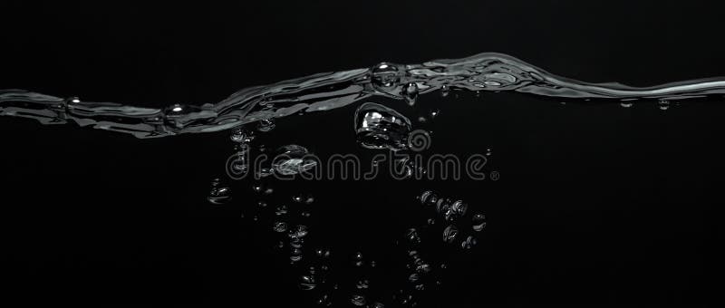 Close up soda water bubbles floating up to top of water surface stock images
