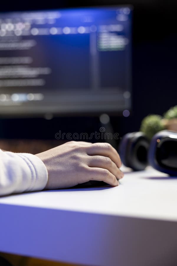 Teleworking IT admin working from RGB lit home, testing and deploying programs and systems. Close up of software technician checking code displayed on computer screens in apartment