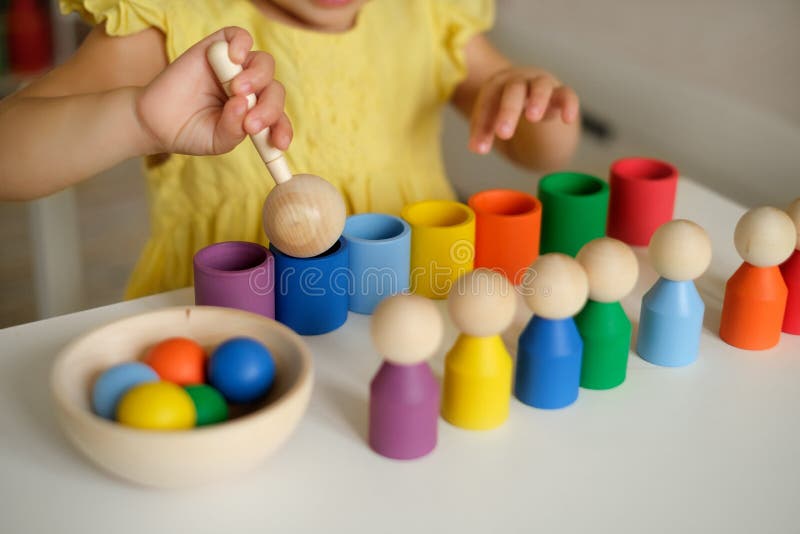 Close-up of a sorter toy with balls, cups and a wooden spoon