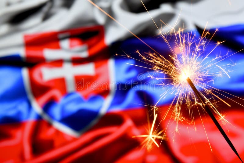 Close up of sparkler burning over Slovakia, Slovakian flag. Holidays, celebration, party concept.