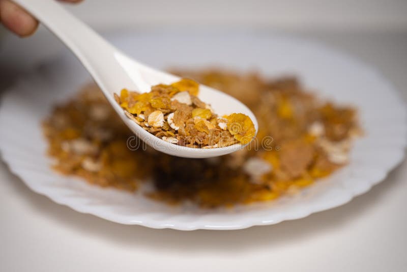 Close up of spoonful Muesli dry fruits, nut, oats, and seeds in white background