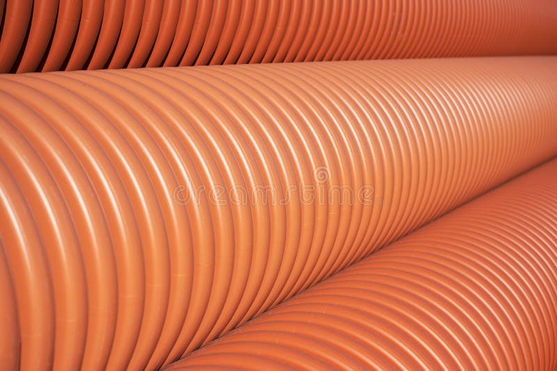 Closeup Stack of New Orange Polypropylene Pipes. Plastic Pipes for
