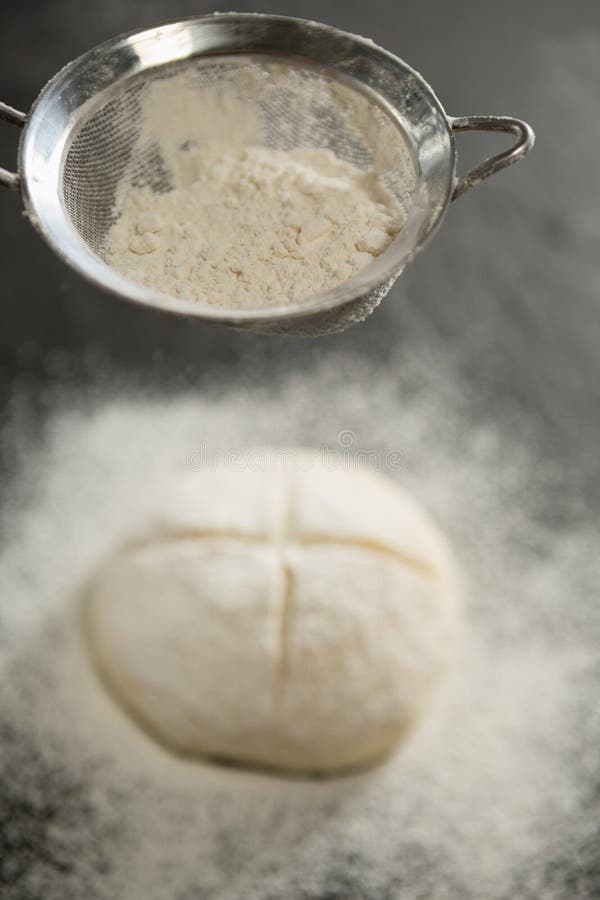 Close up of strainer over bun dough royalty free stock images Close up of strainer over bun dough royalty free stock images
